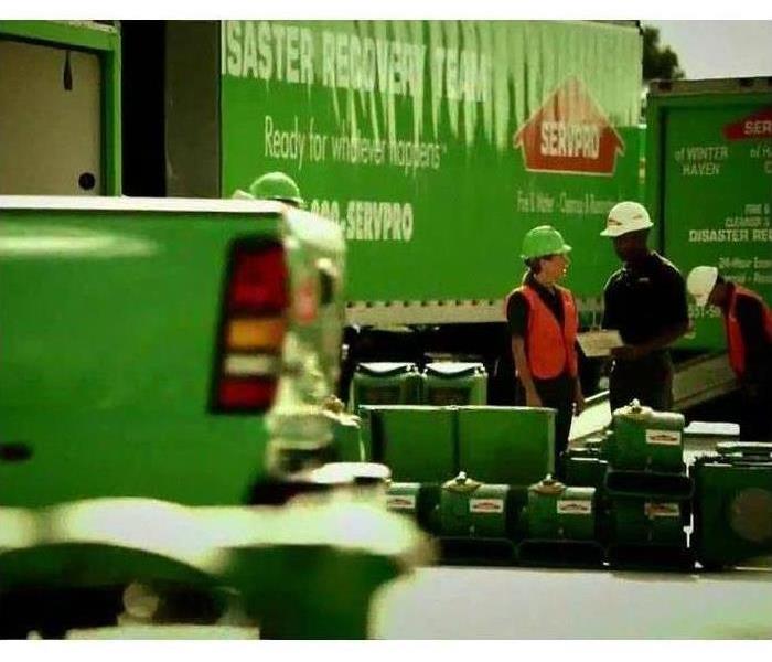 Picture of SERVPRO technicians by SERVPRO vehicles